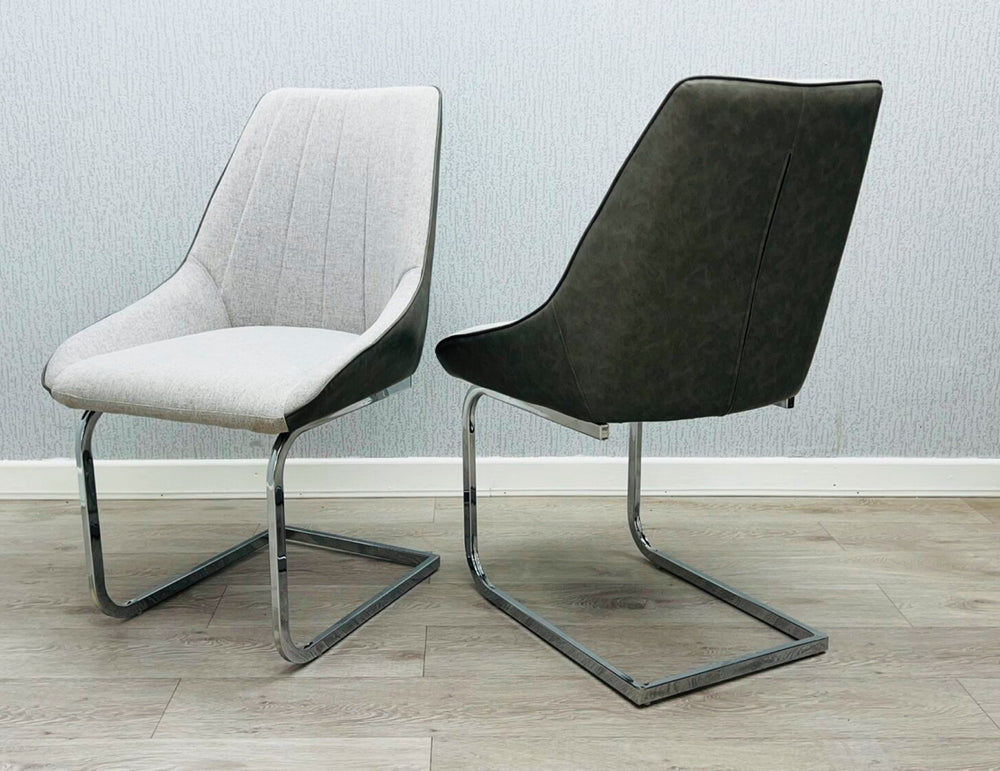 A gray fabric dining chair with a metal frame, pictured against a plain wall on a wooden floor.