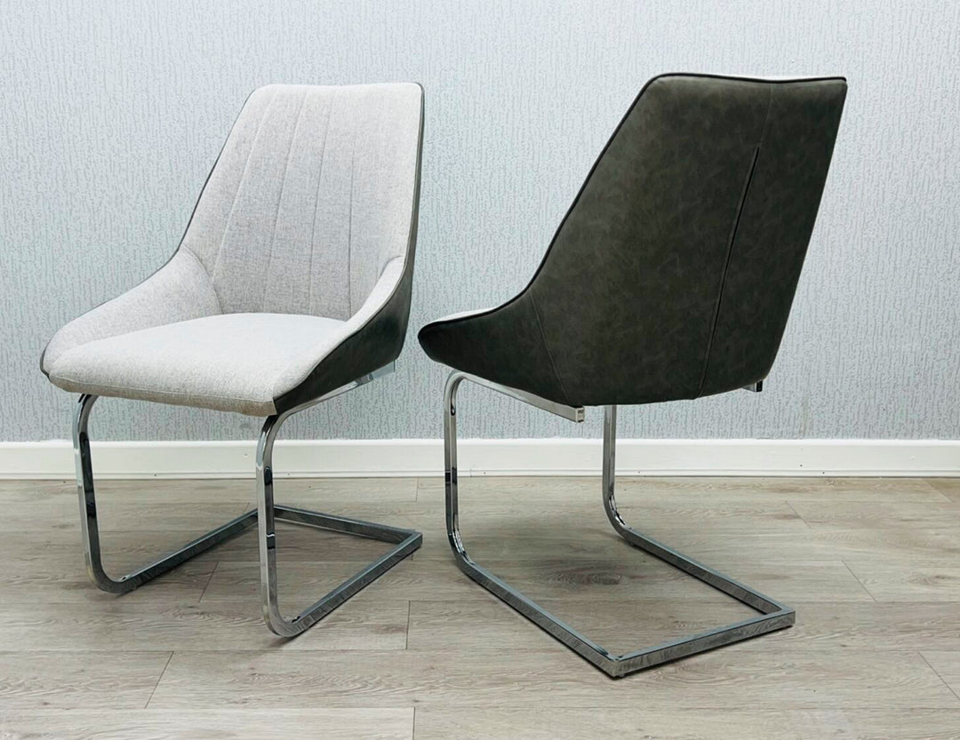 A gray fabric dining chair with a metal frame, pictured against a plain wall on a wooden floor.