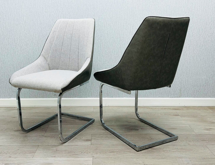 A gray fabric dining chair with a metal frame, pictured against a plain wall on a wooden floor.