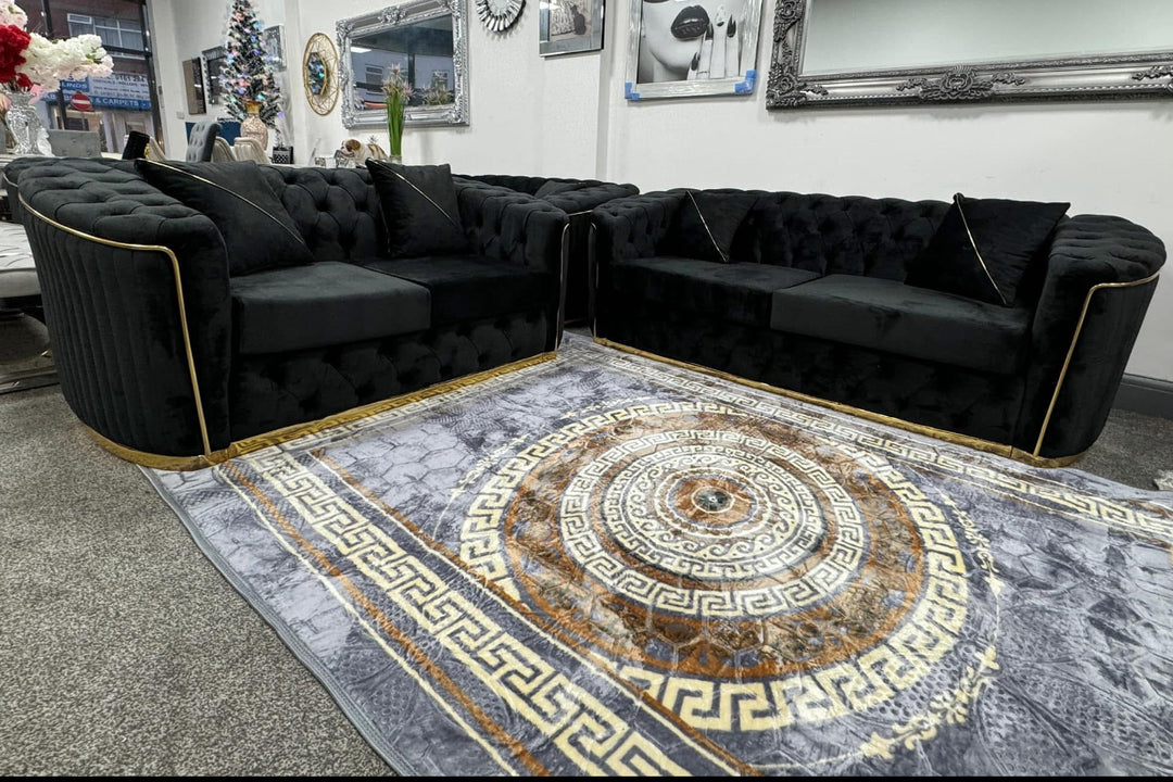 A set of black and gold sofas with tufted detailing, consisting of a 3-seater sofa and a 2-seater sofa, both with a gold-colored metal frame.