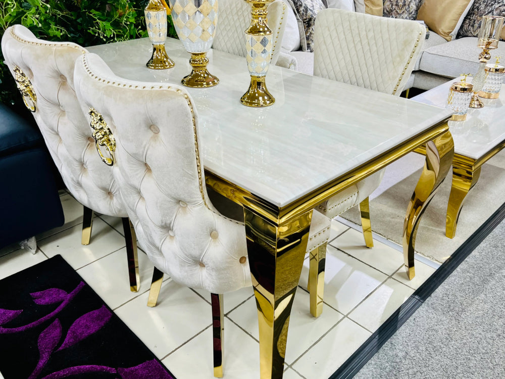 A rectangular cream marble dining table with gold-colored legs and frame.