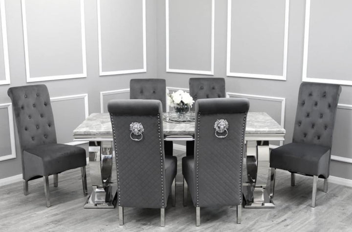 A light grey marble dining table with four upholstered dining chairs featuring chrome legs and a lion knocker on the backrest.