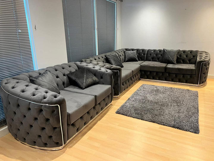 A set of dark grey and chrome sofas with tufted detailing, consisting of a 3-seater sofa and a 2-seater sofa, both with a gold-colored metal frame.