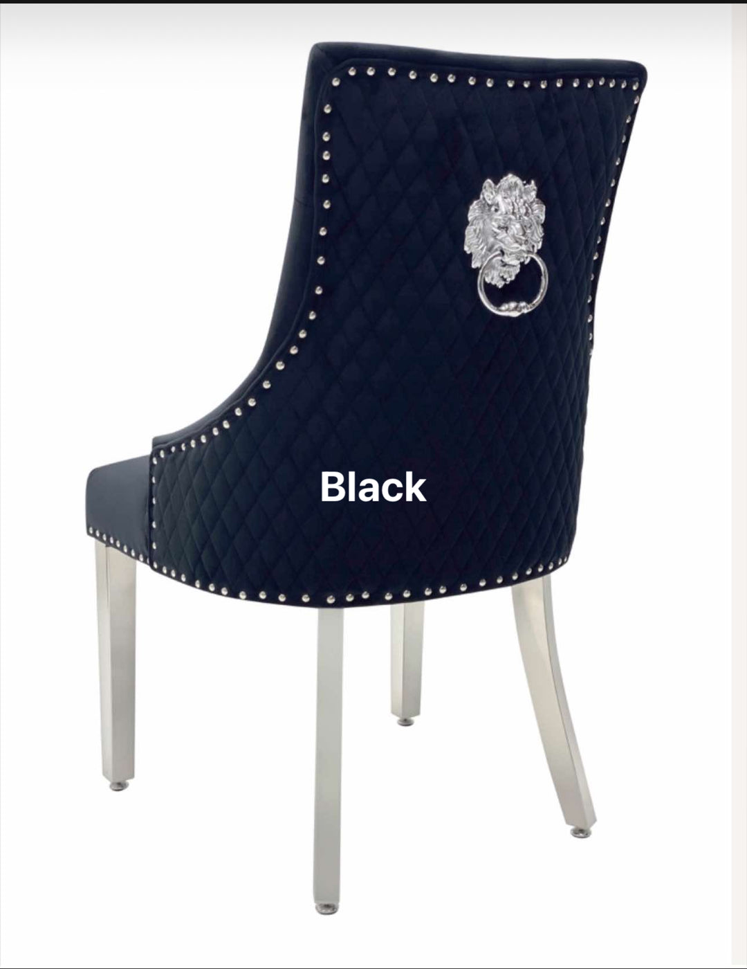 A beige upholstered dining chair with a black lion knocker on the backrest and chrome-colored legs.