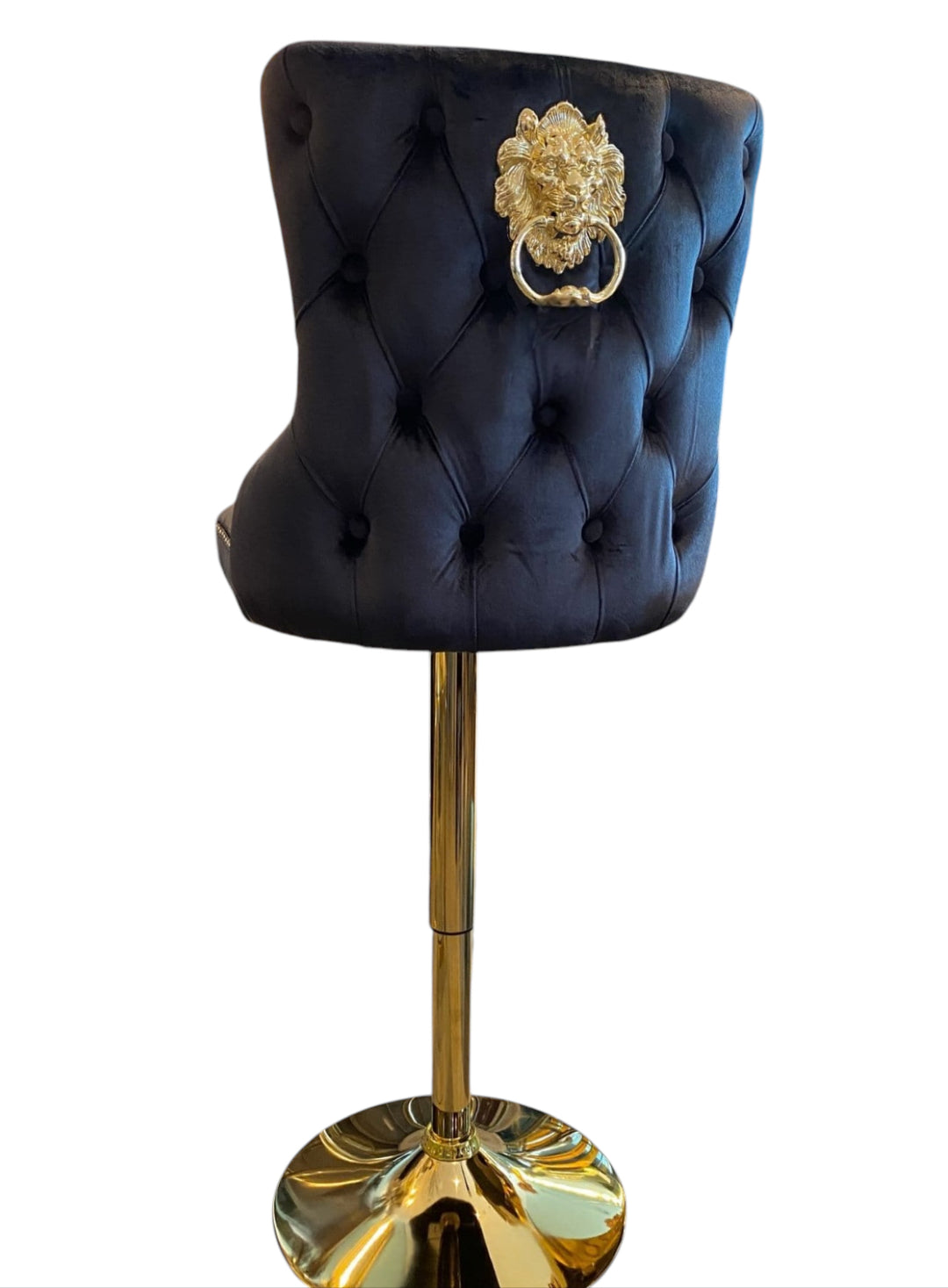 A black colored bar stool with gold accents, featuring a tufted backrest and a lion knocker on the back.