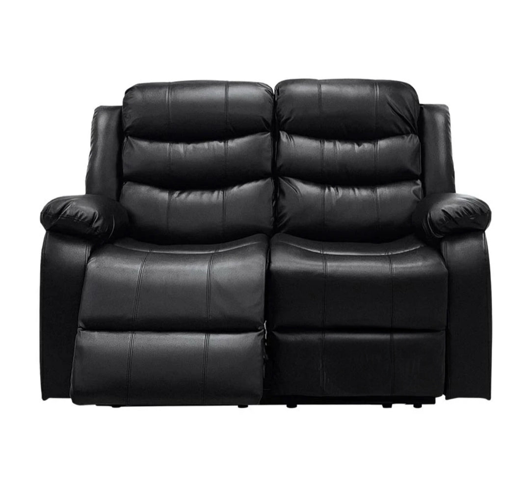A black leather recliner sofa set, consisting of a 2-seater sofa, with drink holders, displayed in a room with grey flooring and skylights.