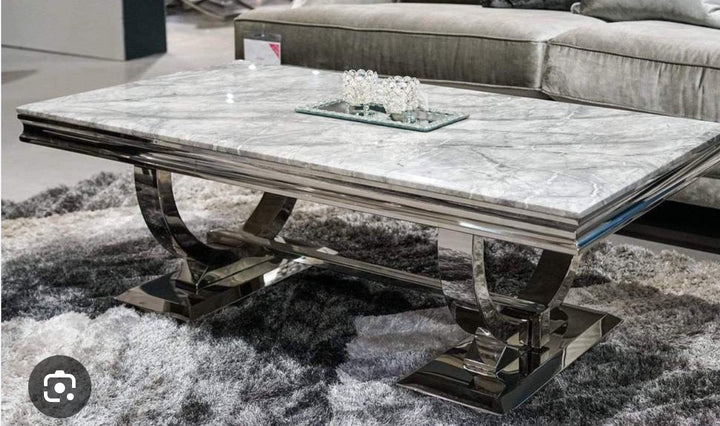 A grey marble coffee table with a chrome leg