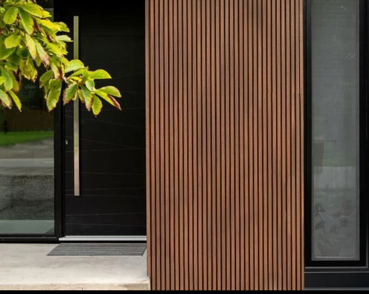 A close-up image of light oak wood slat wall panels with a vertical stripe pattern.