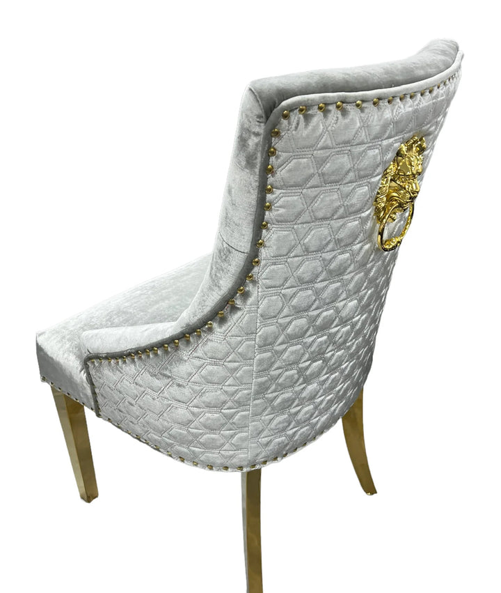A silver dining chair with gold accents and upholstered backrest, seated on a wooden leg.