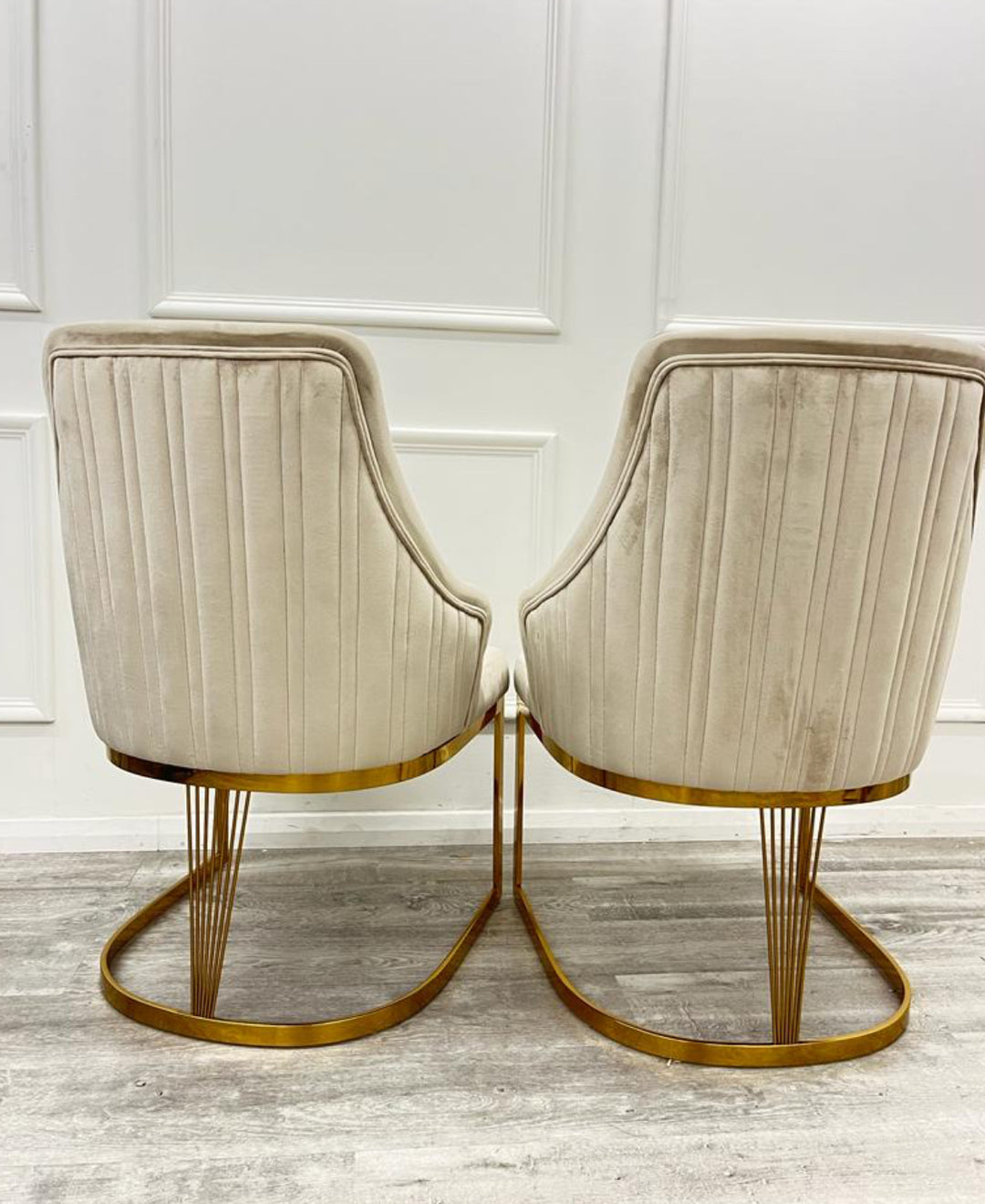 A pair of Chelmsford mink velvet dining chairs with gold stainless steel legs, featuring a ribbed stitch design on the backrest.