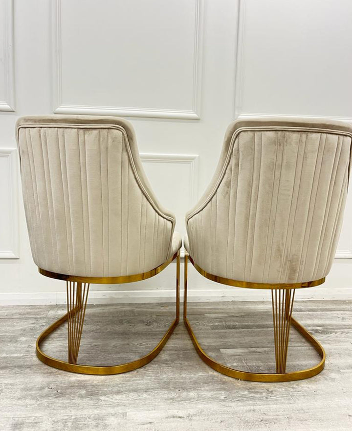 A pair of Chelmsford mink velvet dining chairs with gold stainless steel legs, featuring a ribbed stitch design on the backrest.