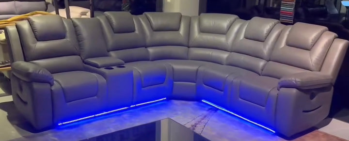 A gray electric recliner corner sofa with integrated cup holders and USB ports, featuring ambient LED lighting and a remote control.