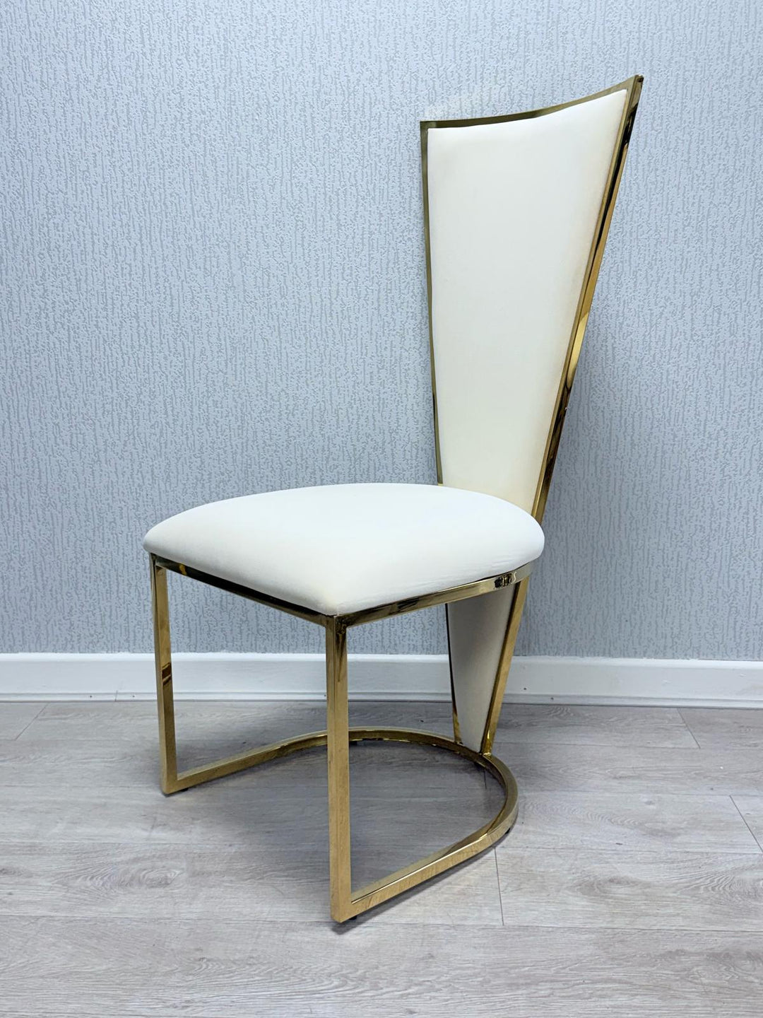 A Vienna cream and gold dining chair with a upholstered seat and a geometric patterned backrest in gold tone.