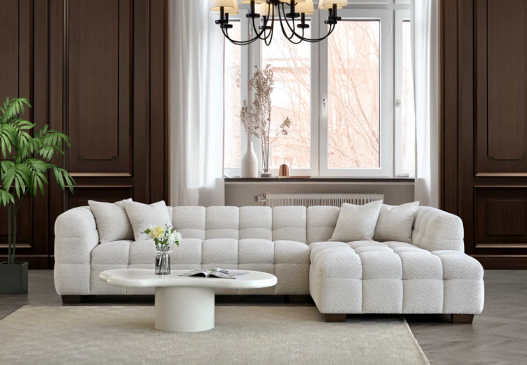 White sectional sofa in a living room with a coffee table and decorative items.
