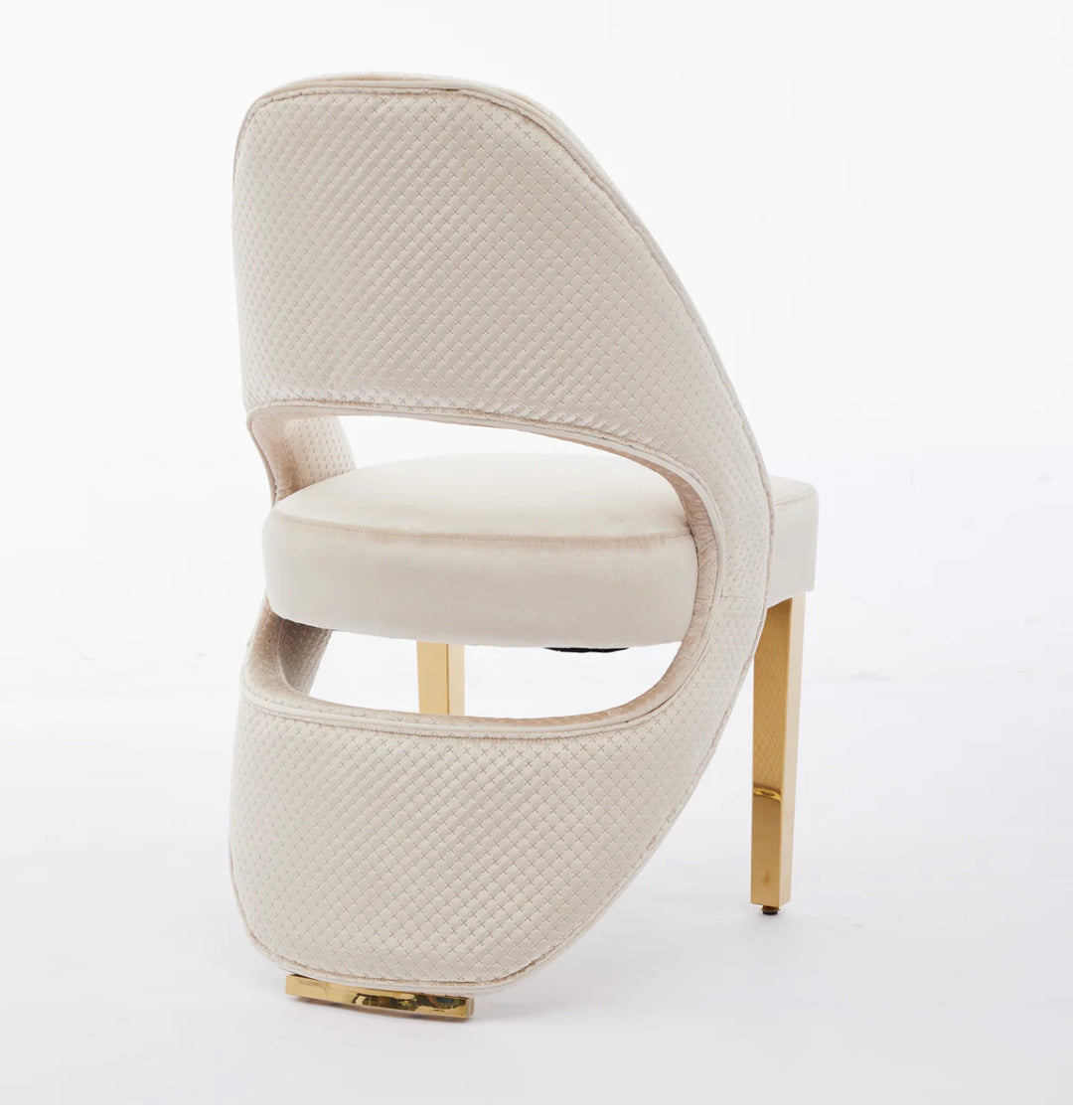 A cream plush velvet dining chair with chrome legs, viewed from a back side angle against a white background.