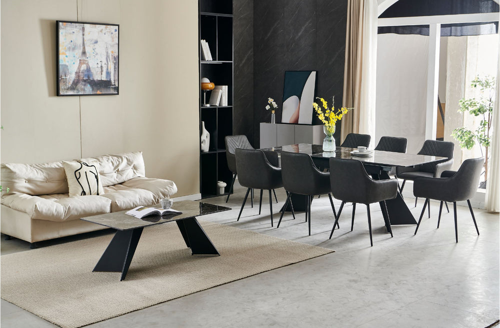 An extendable dining table in black with six dark grey leather chairs, set in a room with minimalist decor.