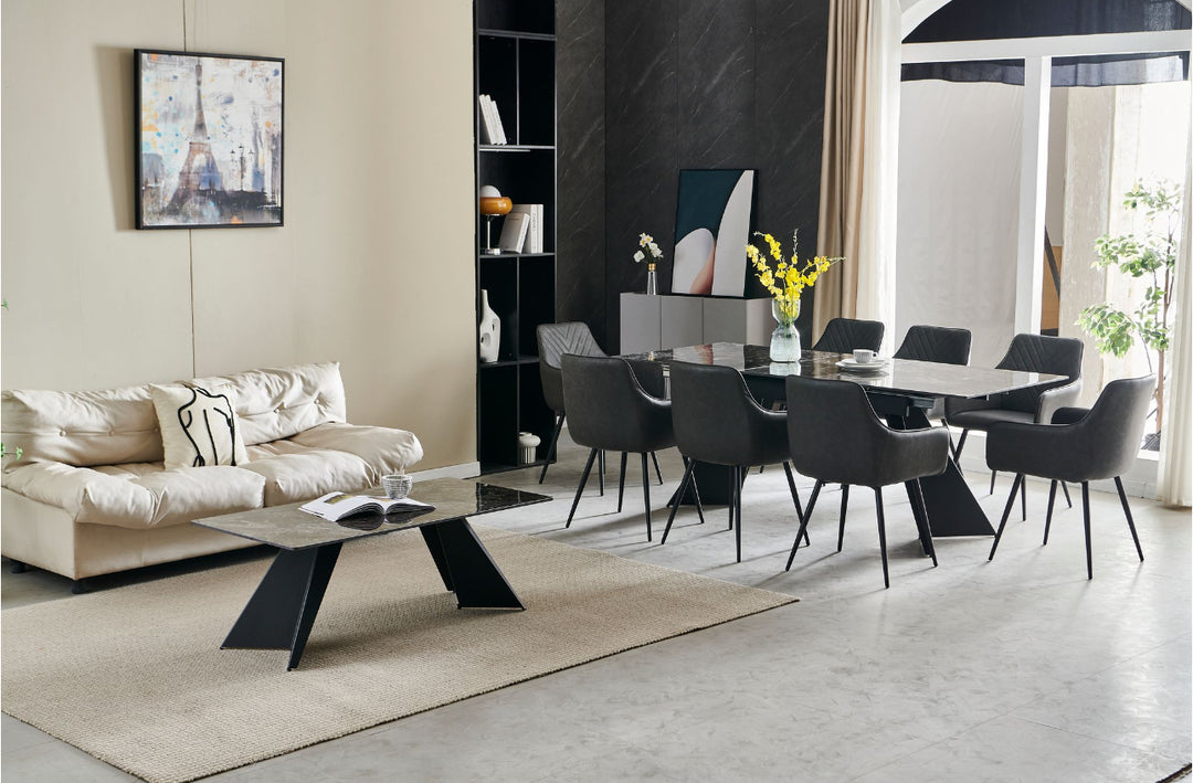 An extendable dining table in black with six dark grey leather chairs, set in a room with minimalist decor.
