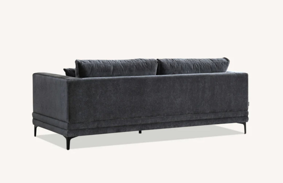 Modern dark grey velvet sofa with square arms, plush cushions, and matching throw pillows on black metal legs