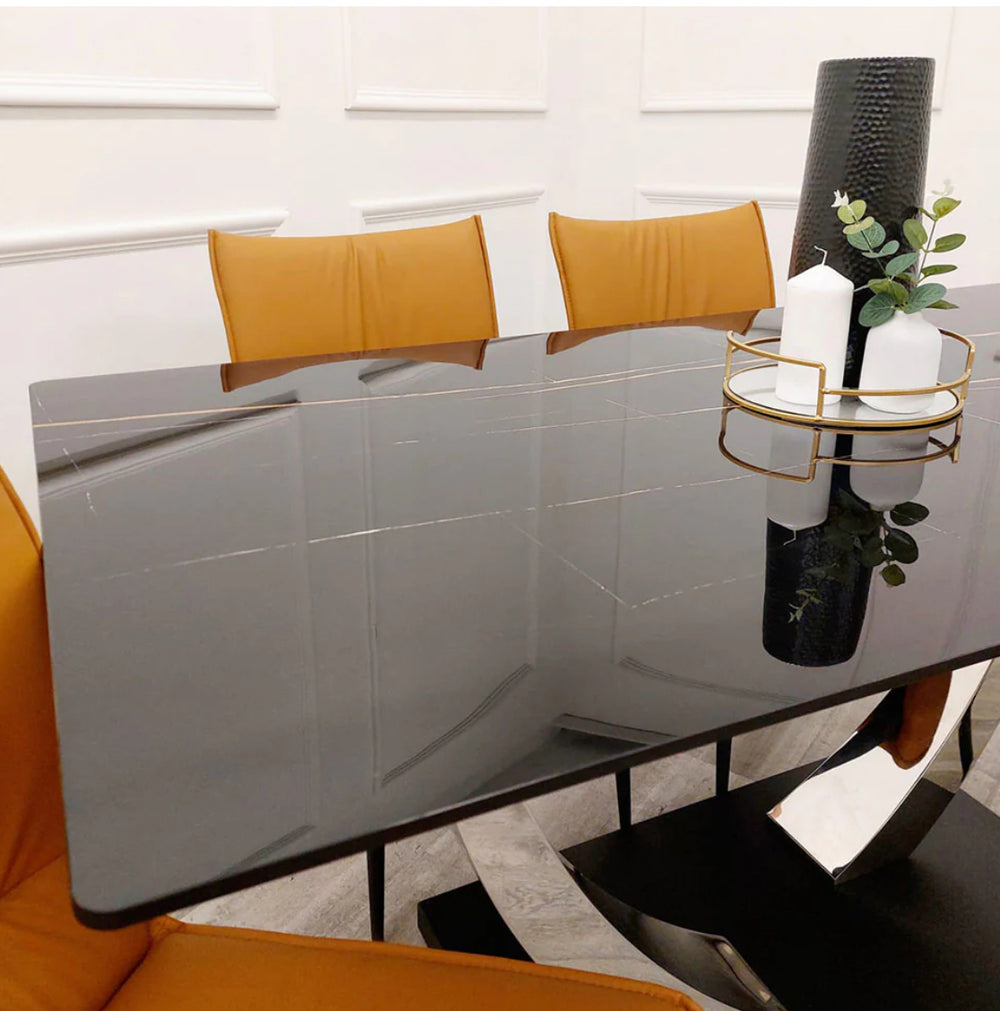Contemporary black dining table with glossy rectangular top and curved chrome legs on a solid black base