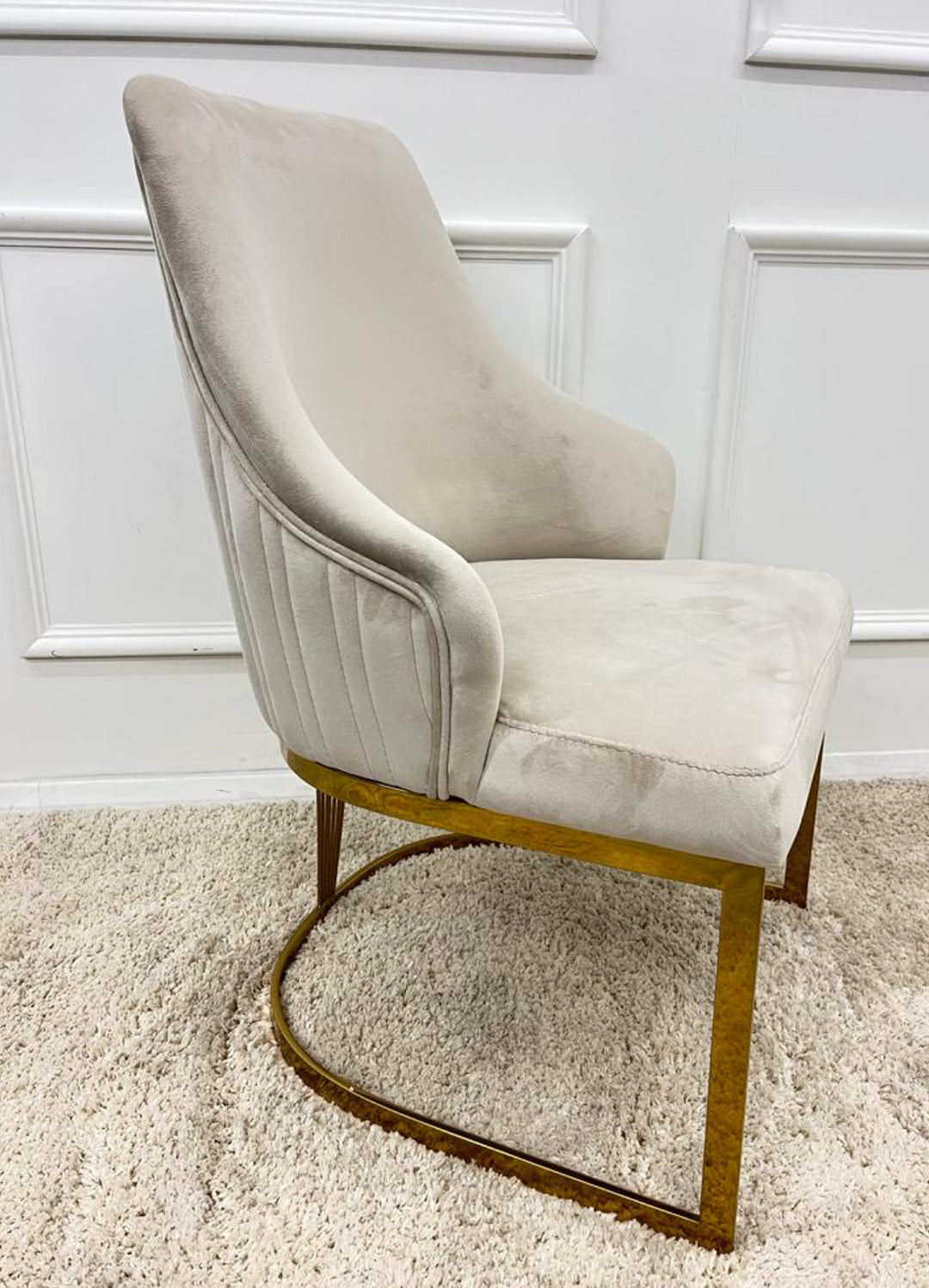 A pair of Chelmsford mink velvet dining chairs with gold stainless steel legs, featuring a ribbed stitch design on the backrest.