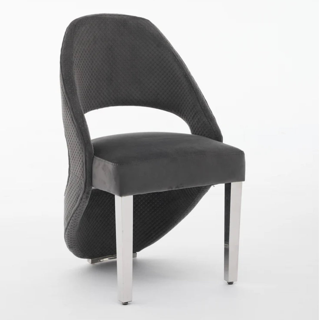 A gray plush velvet dining chair with chrome legs.