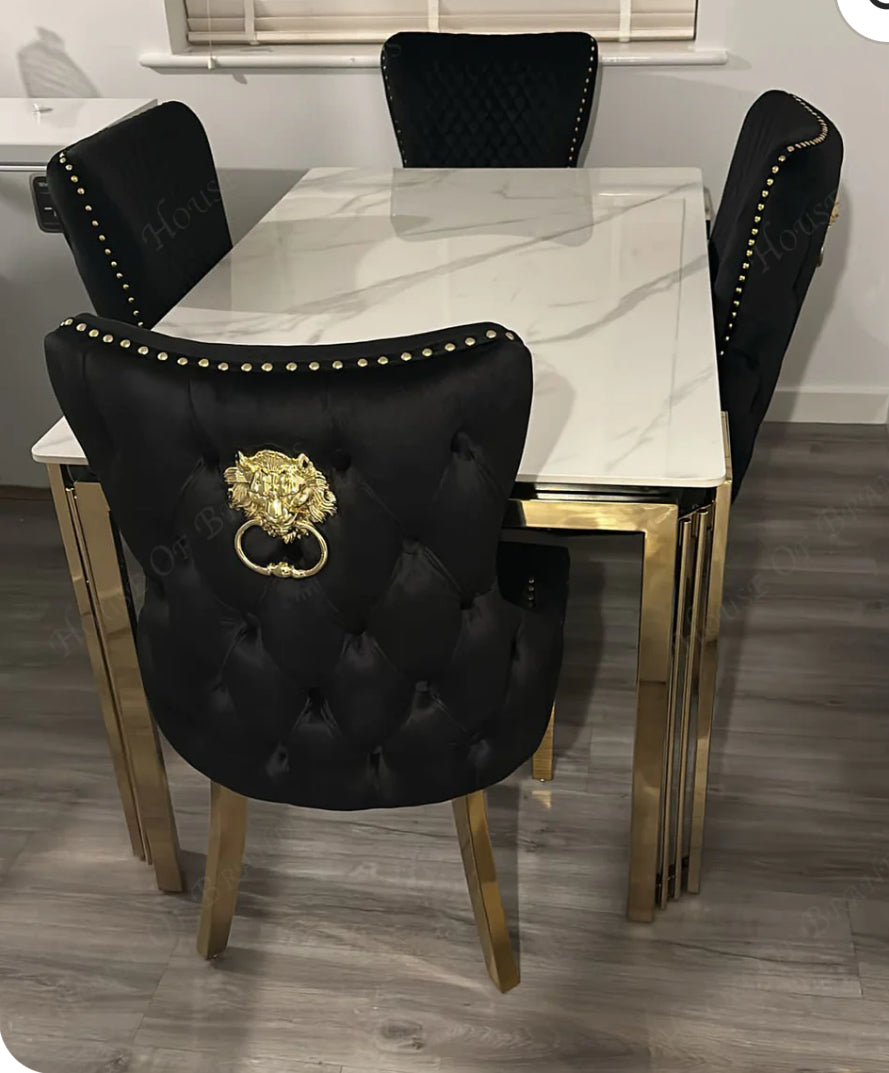 A cream and gold marble dining table with black and gold chairs, set in an interior setting.