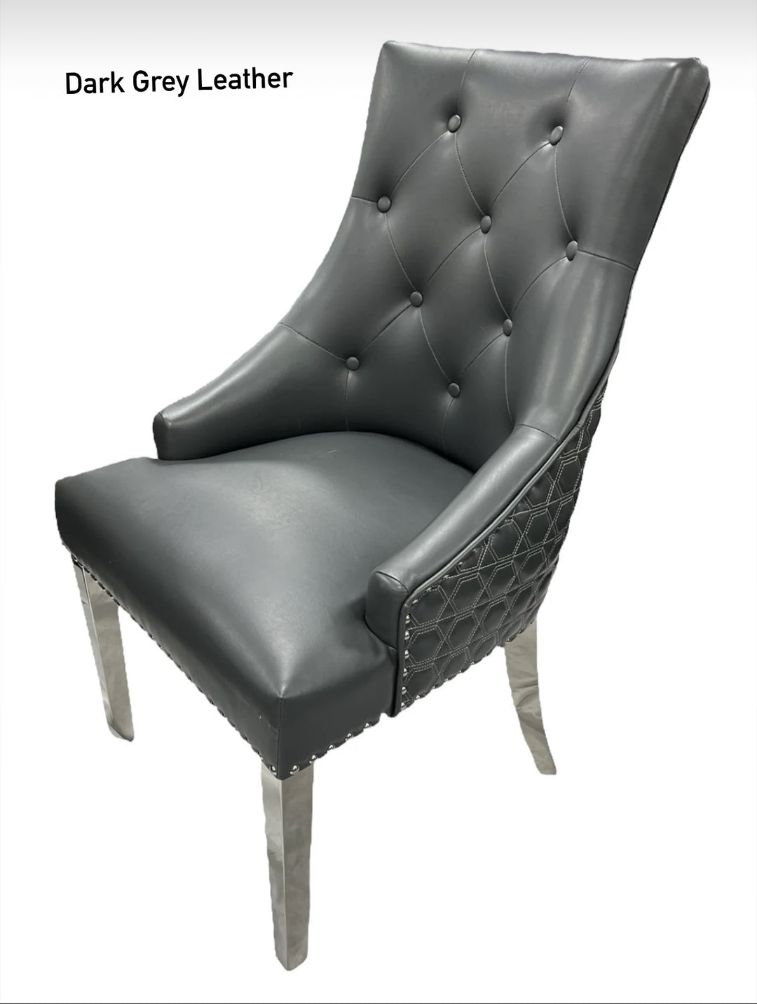 A dark gery leather dining chair with a quilted backrest and button tufting, featuring a metallic Y-shaped frame.