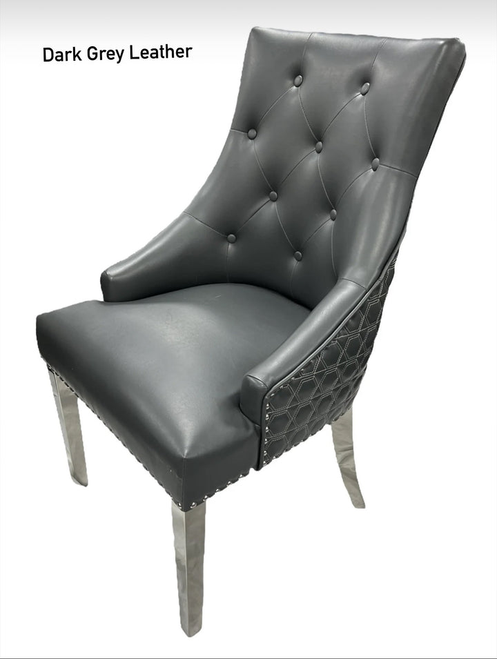 A dark gery leather dining chair with a quilted backrest and button tufting, featuring a metallic Y-shaped frame.