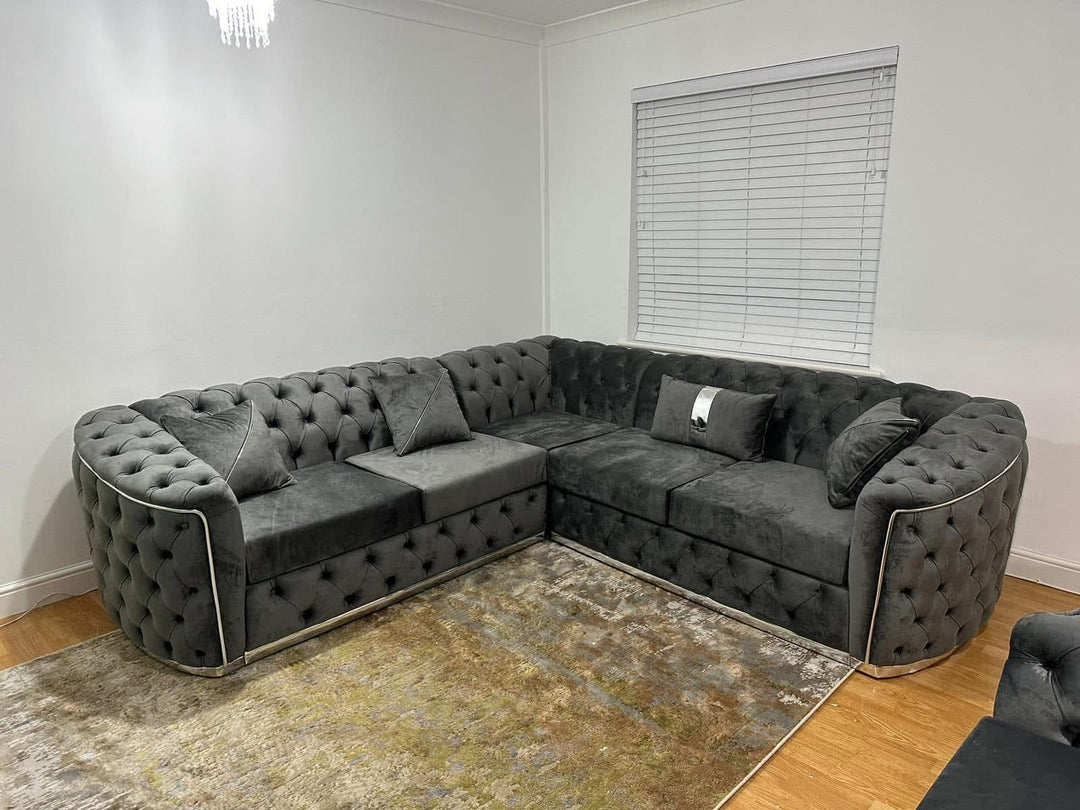 A set of dark grey and chrome sofas with tufted detailing, consisting of a 3-seater sofa and a 2-seater sofa, both with a gold-colored metal frame.