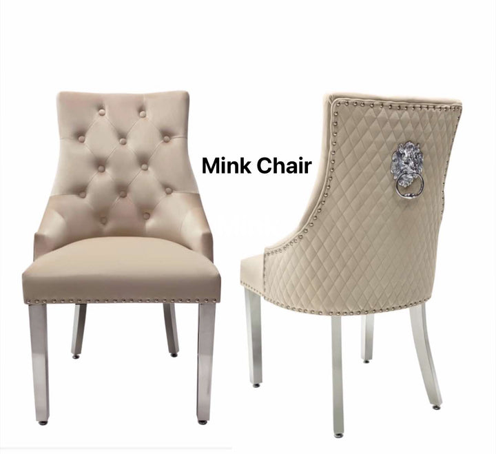 A beige upholstered dining chair with a mink lion knocker on the backrest and chrome-colored legs.