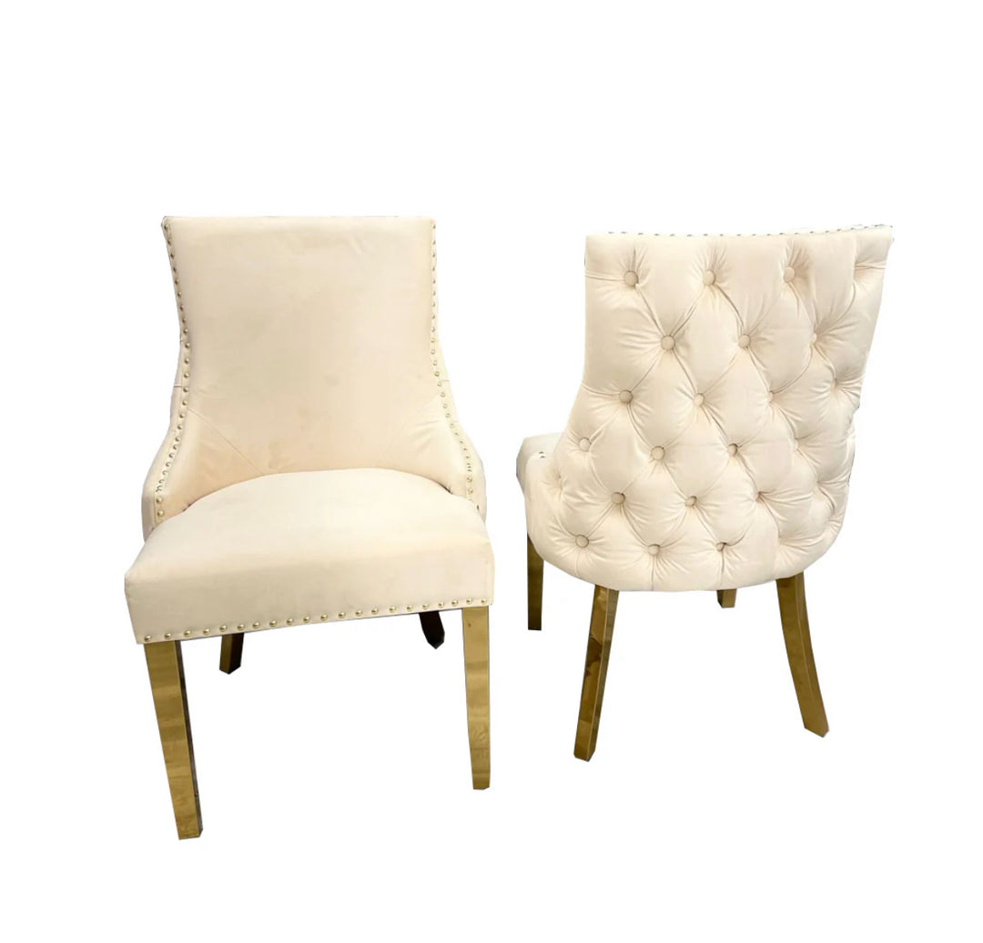 Two Kensington cream dining chairs with gold legs and deep buttoned back design, one showing the side profile and the other showing the back detail.