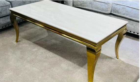A rectangular coffee table with a cream-colored marble top and a gold-colored frame and legs.