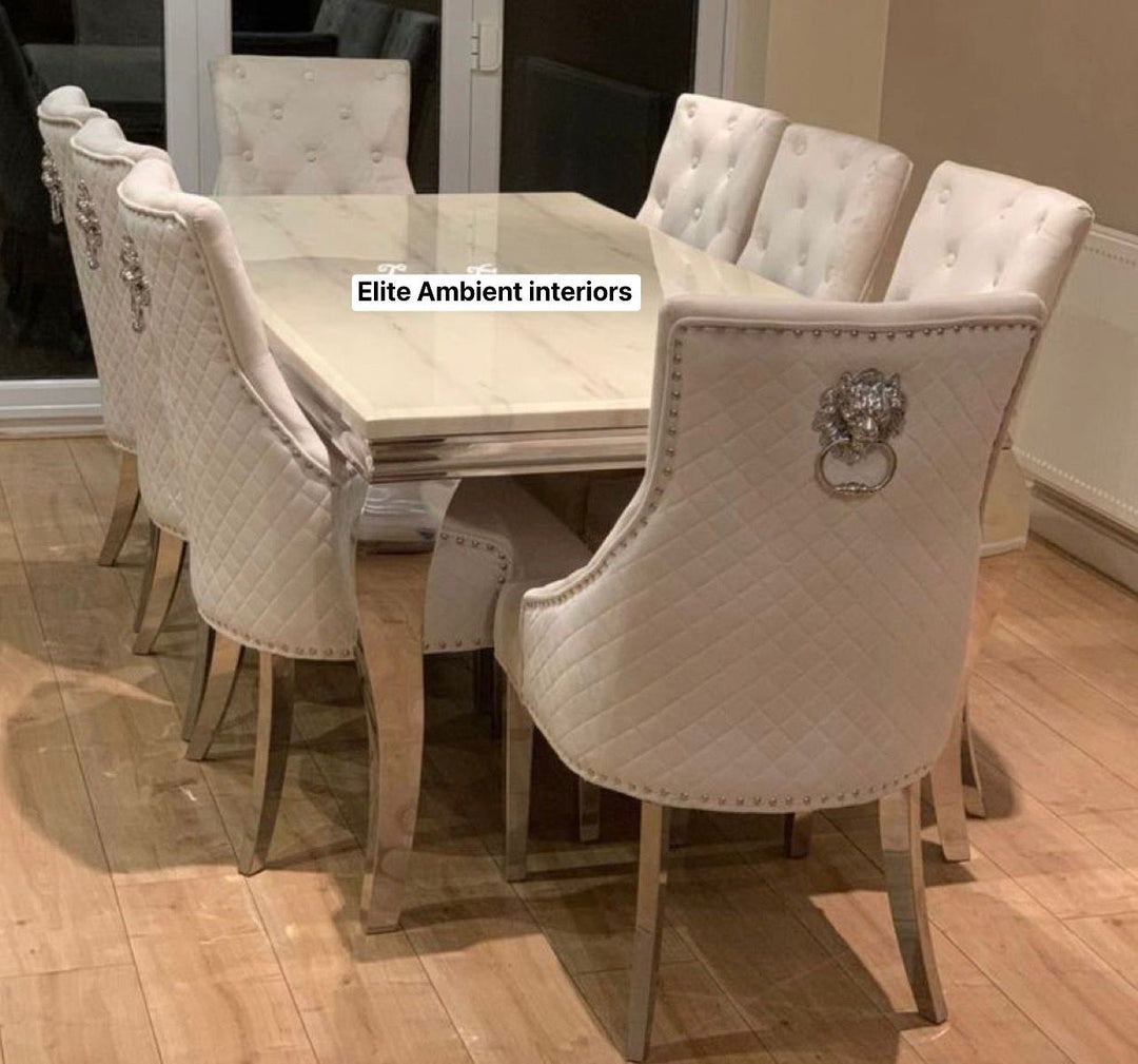 A set of dining furniture featuring a beige marble dining table with six upholstered dining chairs, the chairs have chrome detailing and are arranged around the table.