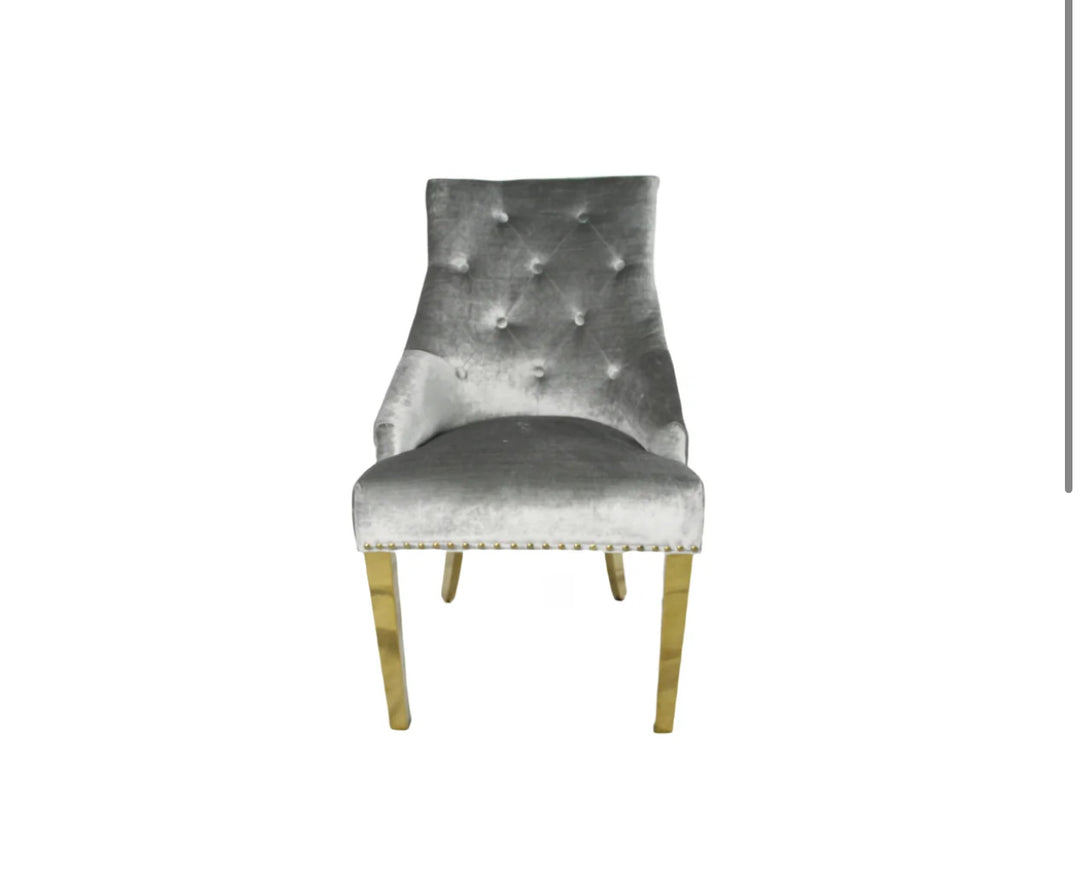 A silver dining chair with gold accents and upholstered backrest, seated on a wooden leg.