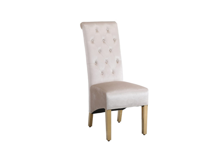 A beige upholstered dining chair with a gold-colored metal frame and a square knocker on the backrest.