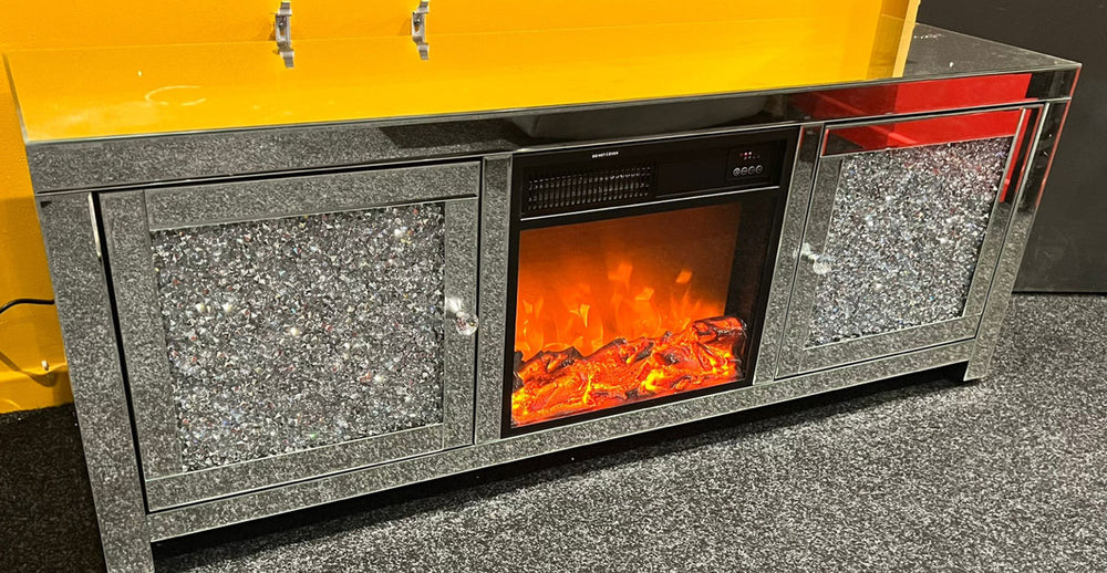 A modern silver mirrored TV unit with a fireplace insert and crushed diamond pattern detailing.