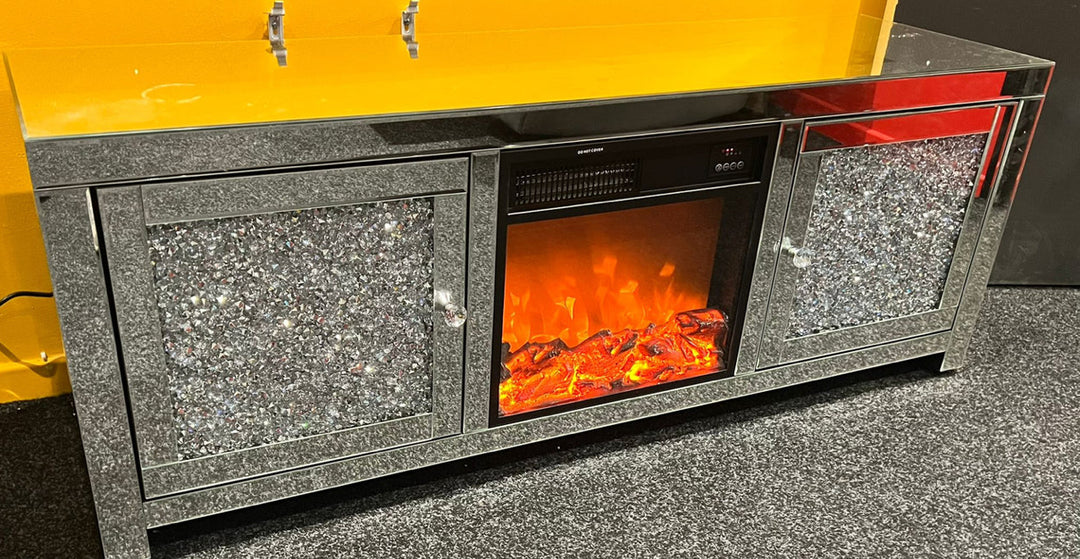 A modern silver mirrored TV unit with a fireplace insert and crushed diamond pattern detailing.