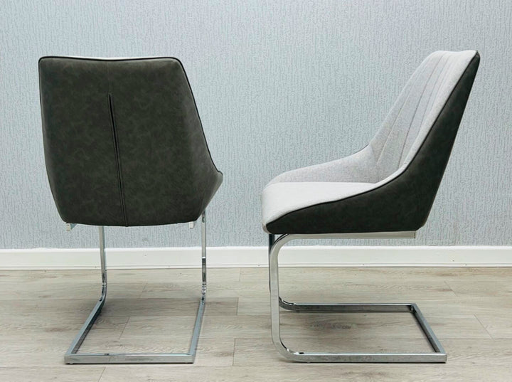 A gray fabric dining chair with a metal frame, pictured against a plain wall on a wooden floor.