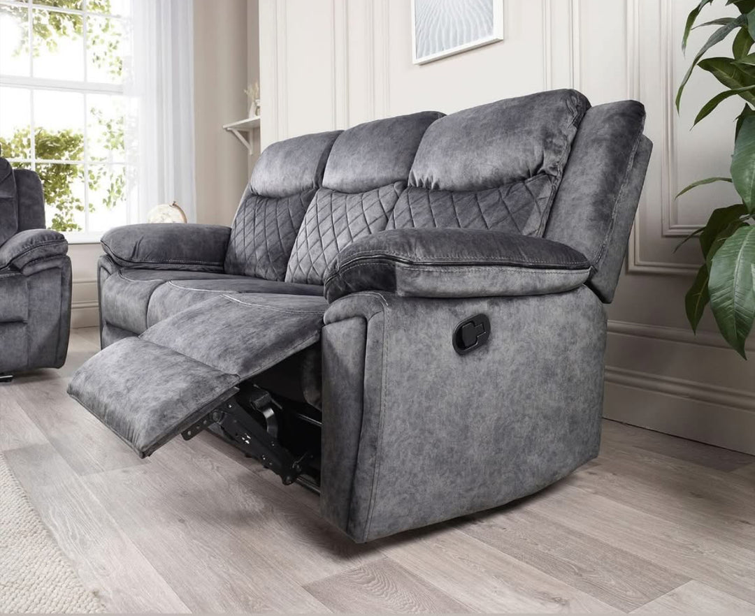 A silver grey leather recliner sofa set consisting of a three-seater sofa, a two-seater sofa, and an armchair, arranged in a living room setting with a center table.