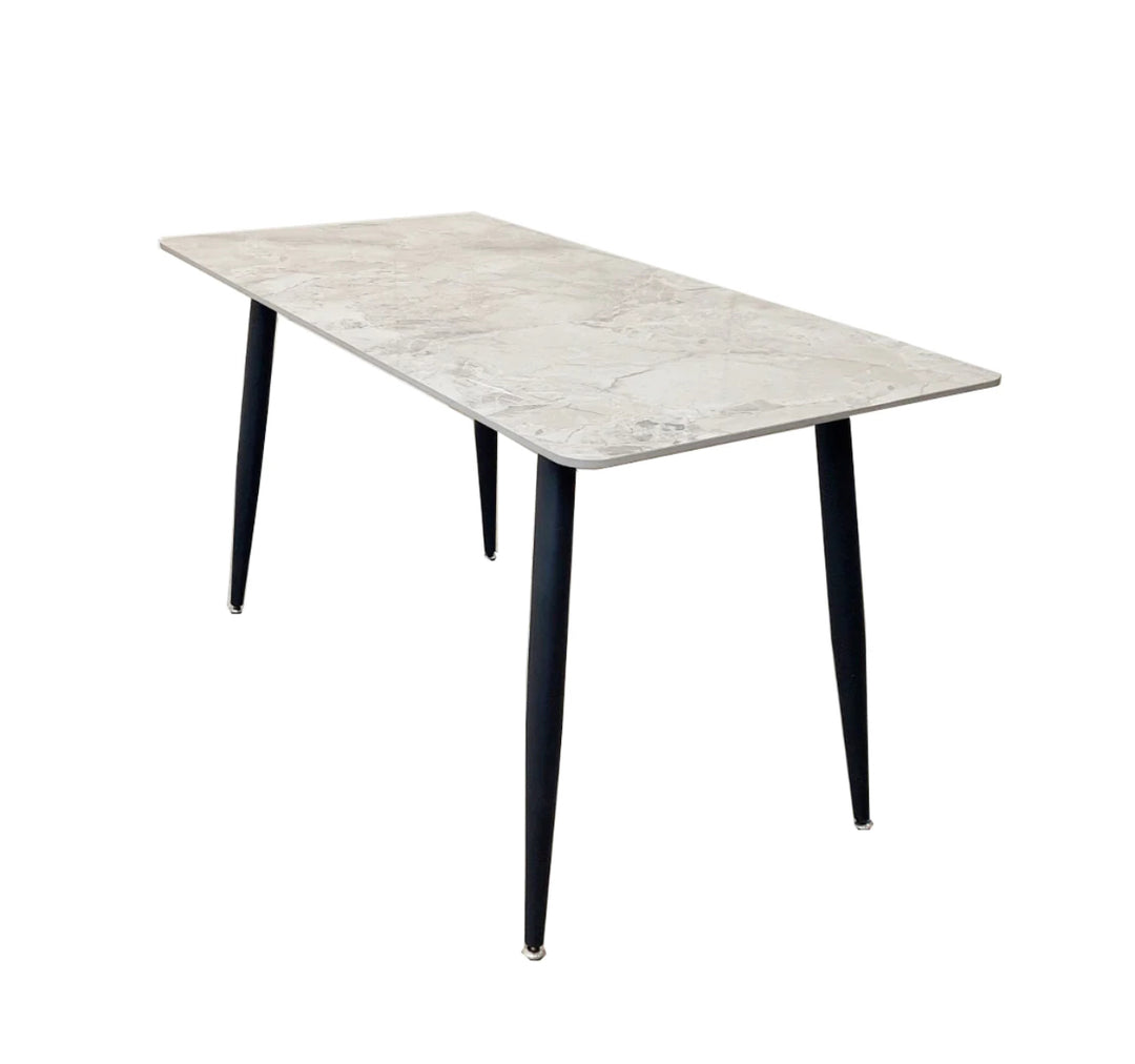 A black dining table with a grey sintered stone top and black tapered legs.