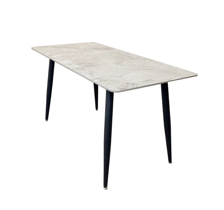 A black dining table with a grey sintered stone top and black tapered legs.