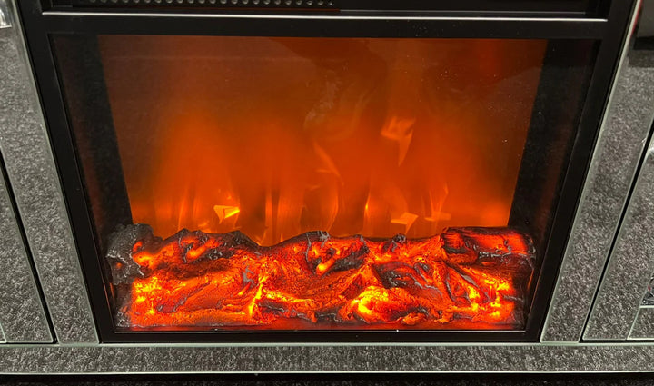 A modern silver mirrored TV unit with a fireplace insert and crushed diamond pattern detailing.