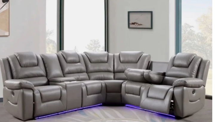 A gray electric recliner corner sofa with integrated cup holders and USB ports, featuring ambient LED lighting and a remote control.