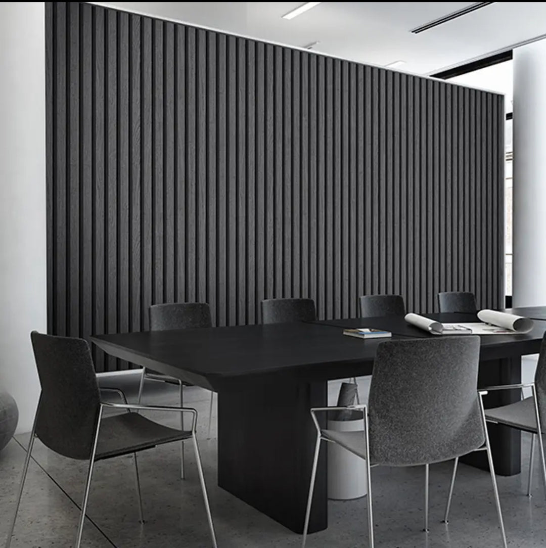 A set of wood effect veneer wall panels in an ash grey color, installed on a wall with a table and chairs in front of them.