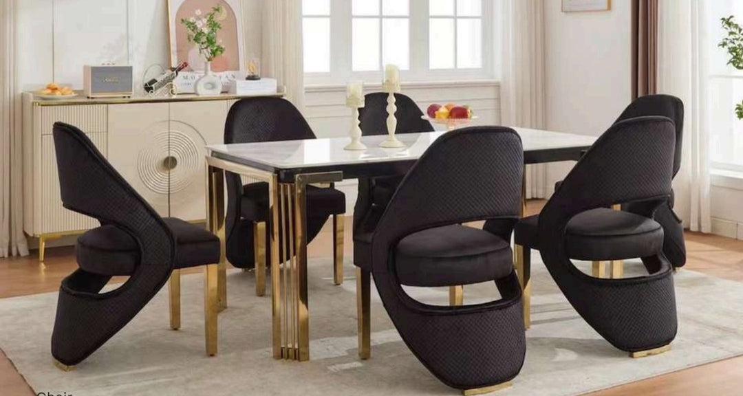A rectangular white dining table with gold legs, surrounded by black and gold chairs with a contemporary design.