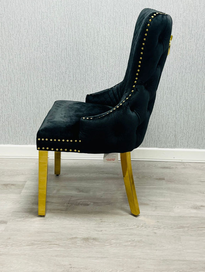 Black upholstered chair with gold accents on a light wooden floor.