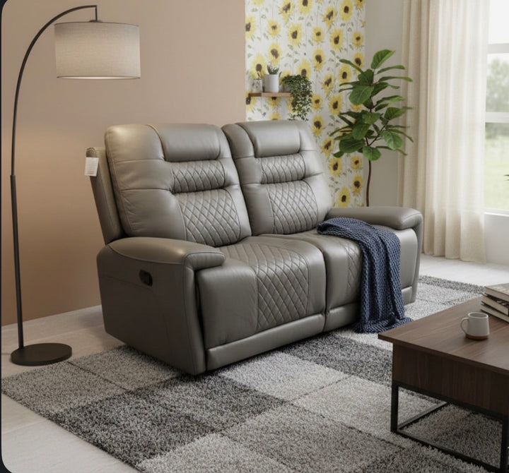 2 Seater Gray recliner sofa in a living room setting with a rug, coffee table, and decorative elements.