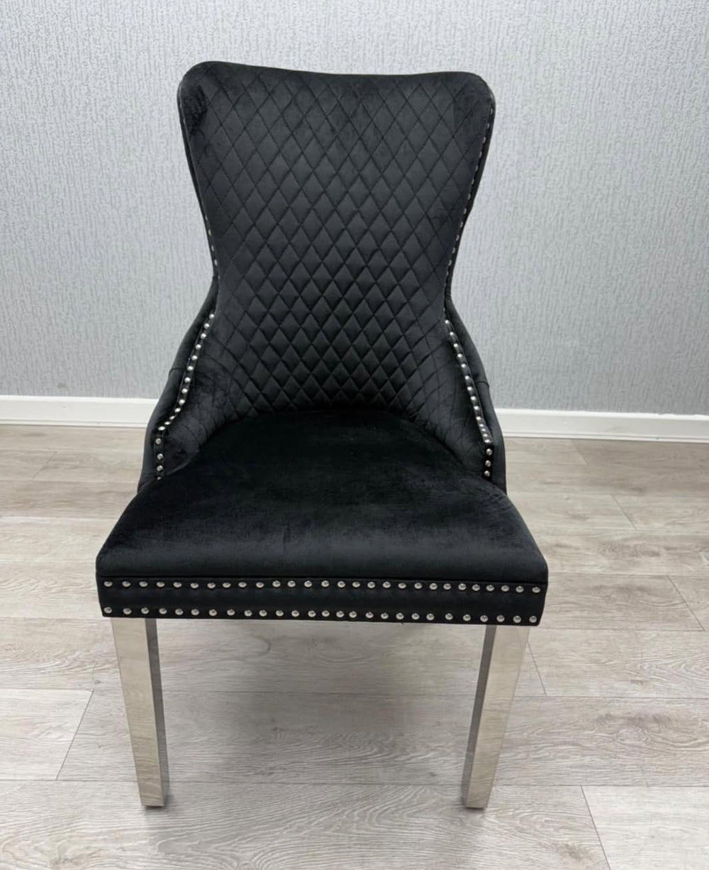 Black quilted chair with silver legs on a wooden floor.