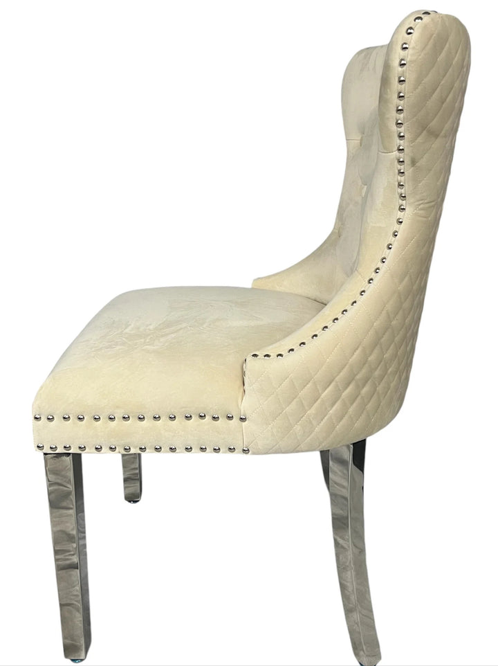 Beige upholstered chair with nailhead trim on a white background