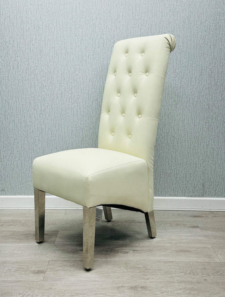 A single cream-colored dining chair with a high tufted backrest and upholstered back, seat, and legs made of wood.